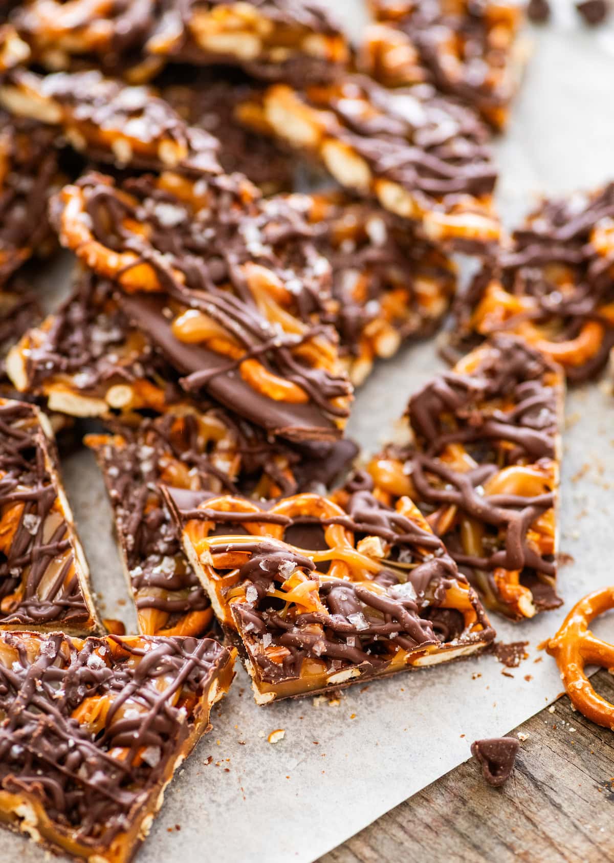chocolate caramel pretzel bark cut into pieces on parchment paper.