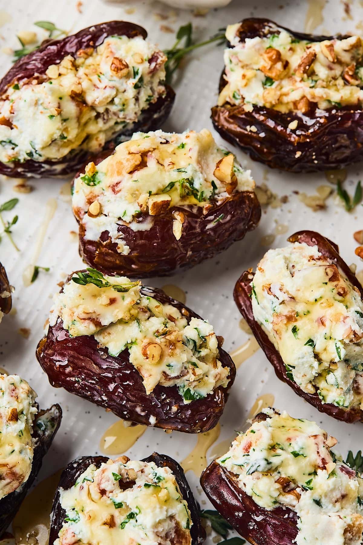 close up of stuffed dates with goat cheese, bacon, and pecans with a drizzle of honey.