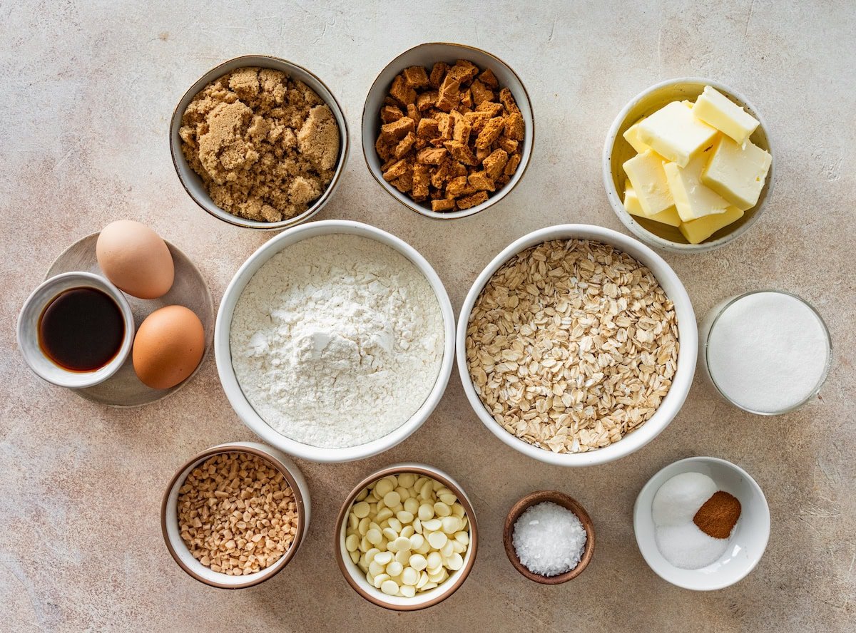 ingredients in bowls to make Brown Butter Oatmeal Biscoff Cookies with Toffee & White Chocolate.