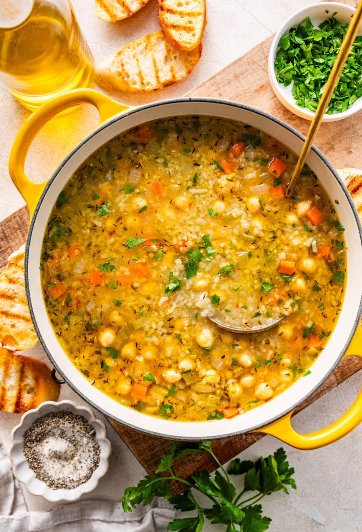 chickpea and rice soup in a large pot with a gold ladle.