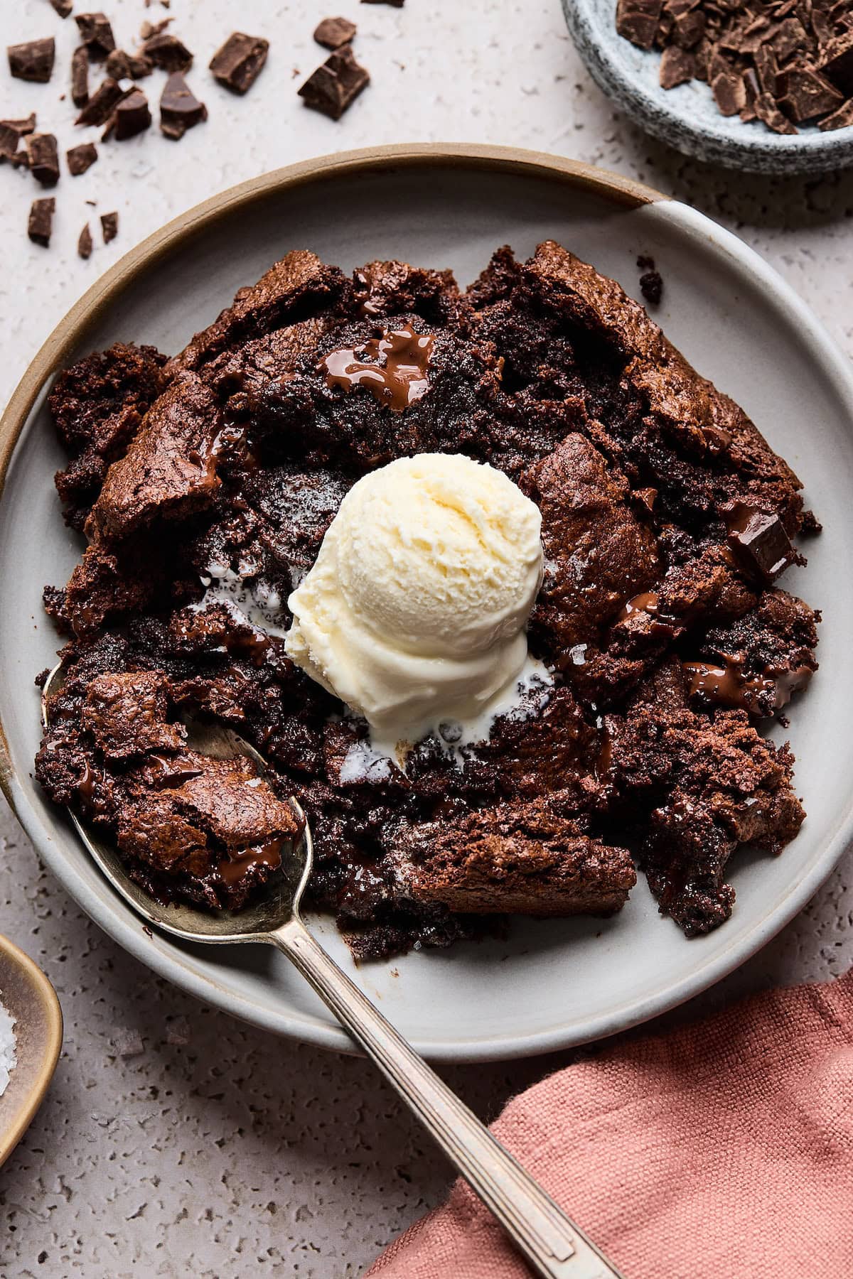 chocolate skillet cookie dessert on plate with vanilla ice cream and spoon.