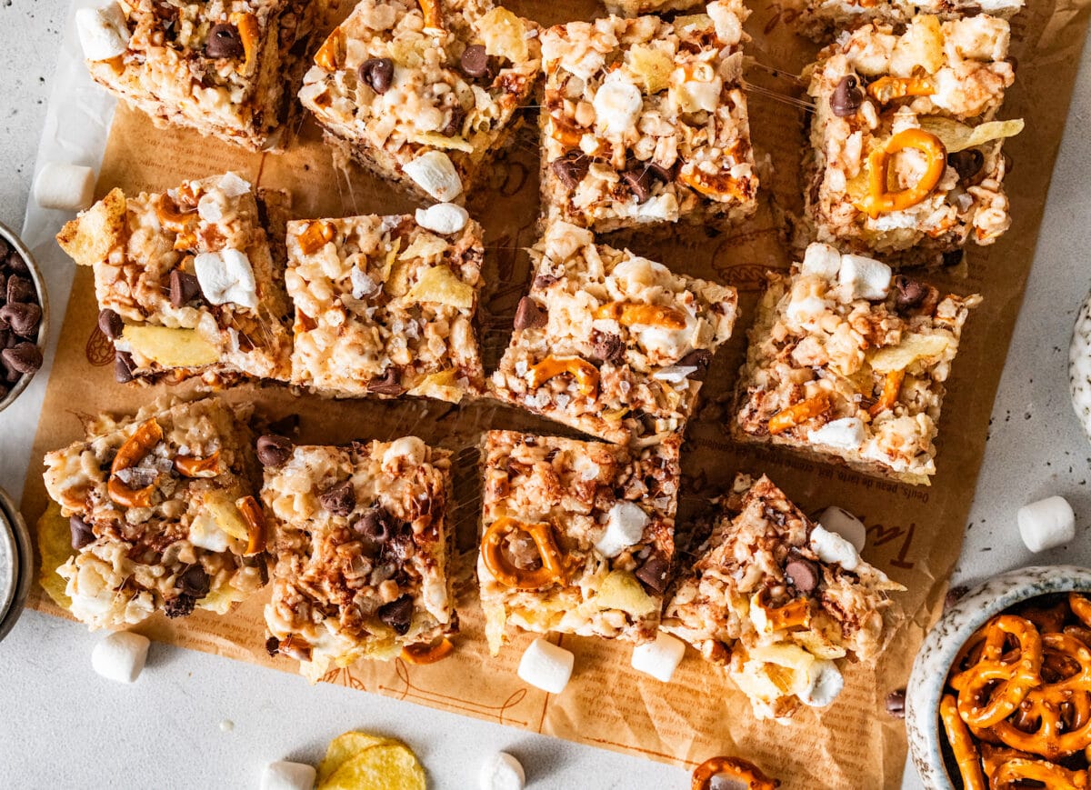 sweet and salty rice krispie treats cut into squares on parchment paper.