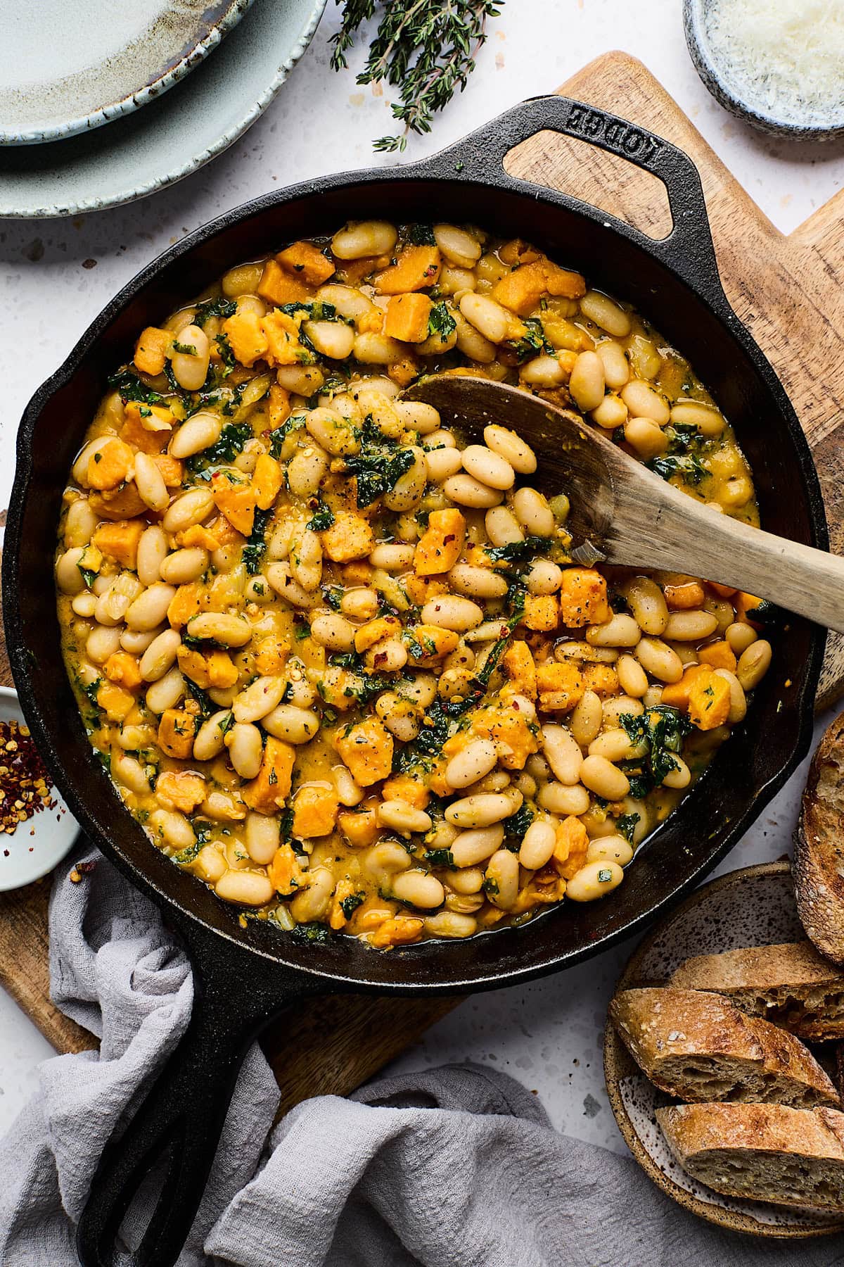 sweet potato white bean skillet with wooden spoon.