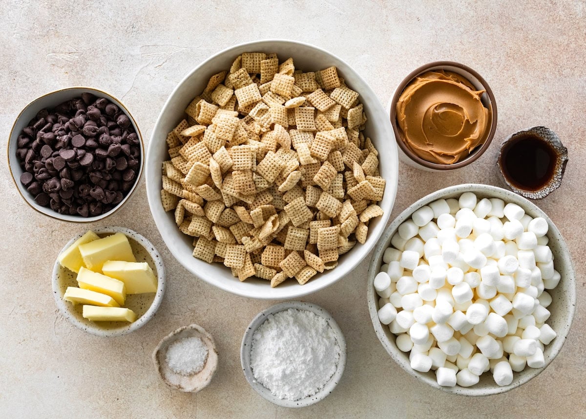ingredients in bowls to make puppy chow marshmallow treats.