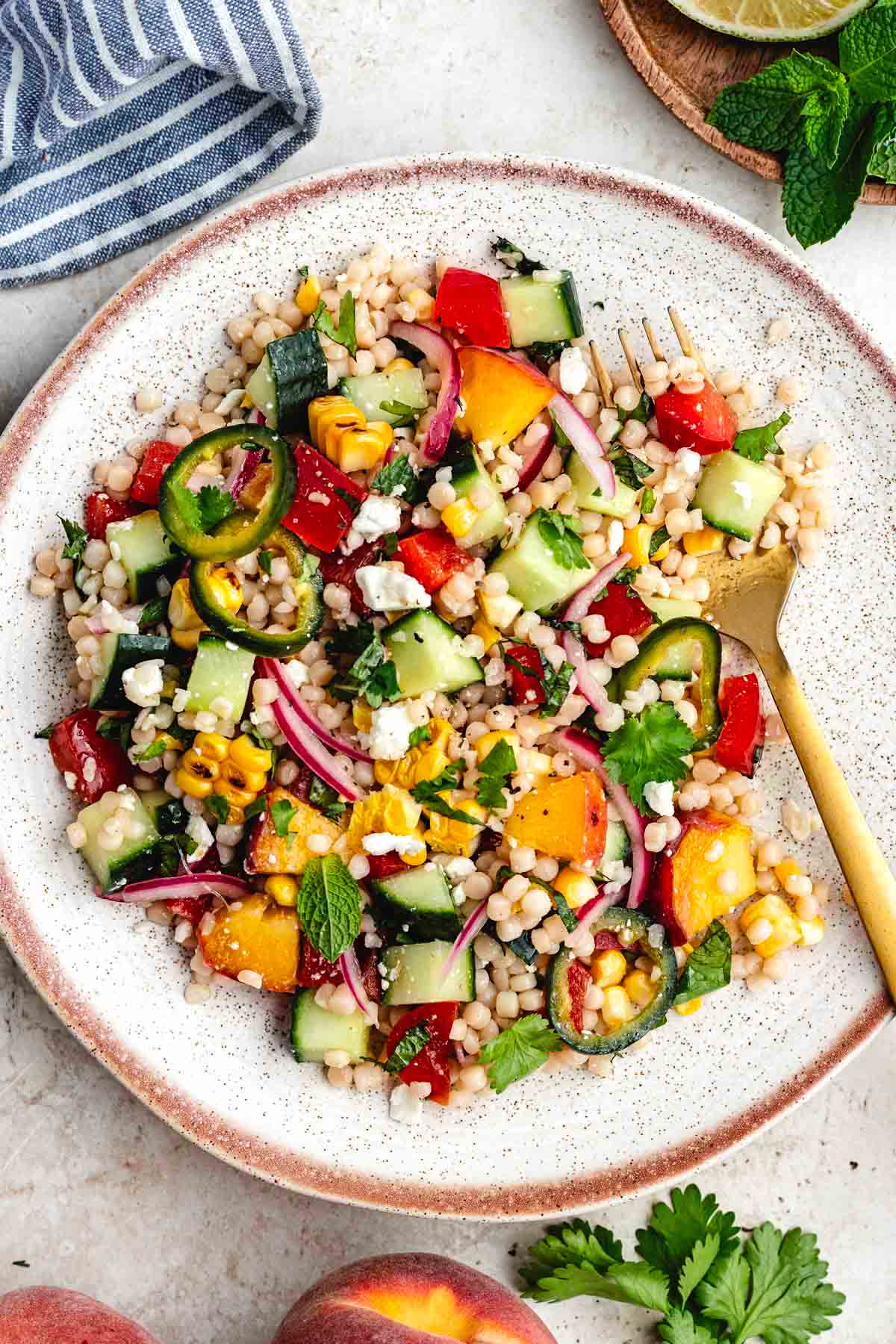 summer couscous salad on plate with fork.