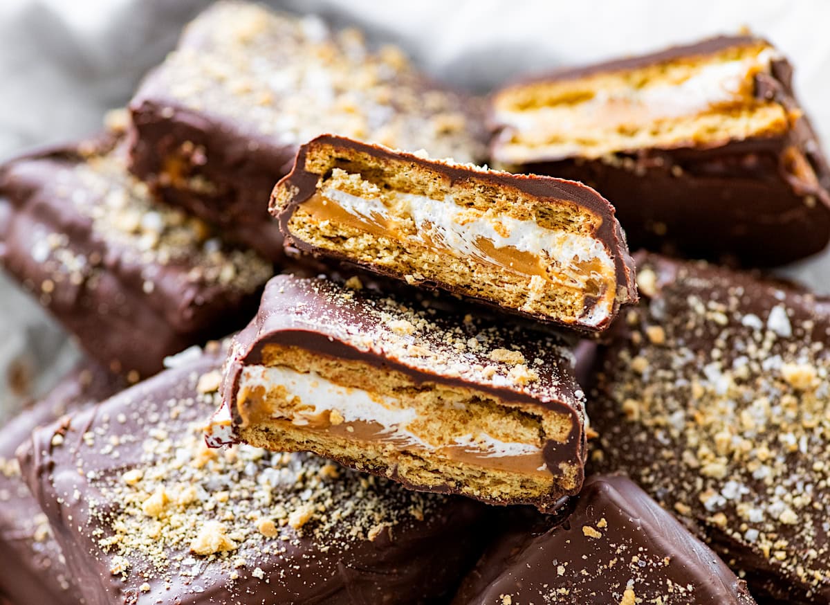 chocolate covered s'mores graham cracker sandwich with peanut butter layer broken in half.