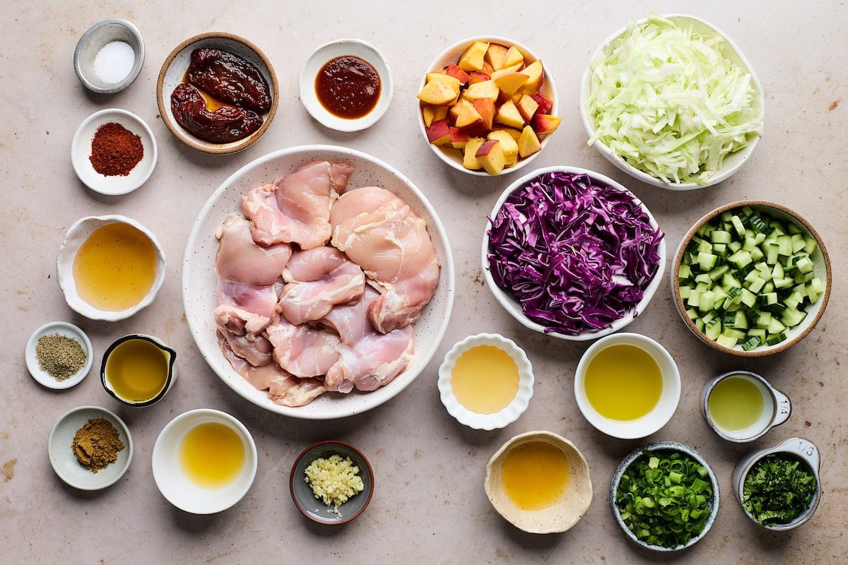 ingredients in bowls to make honey chipotle chicken thighs with peach slaw.