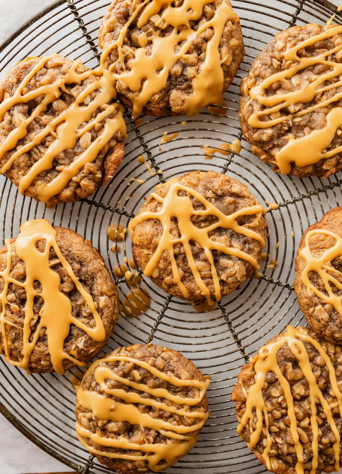 apple oatmeal cookies with salted caramel glaze on cooling rack.