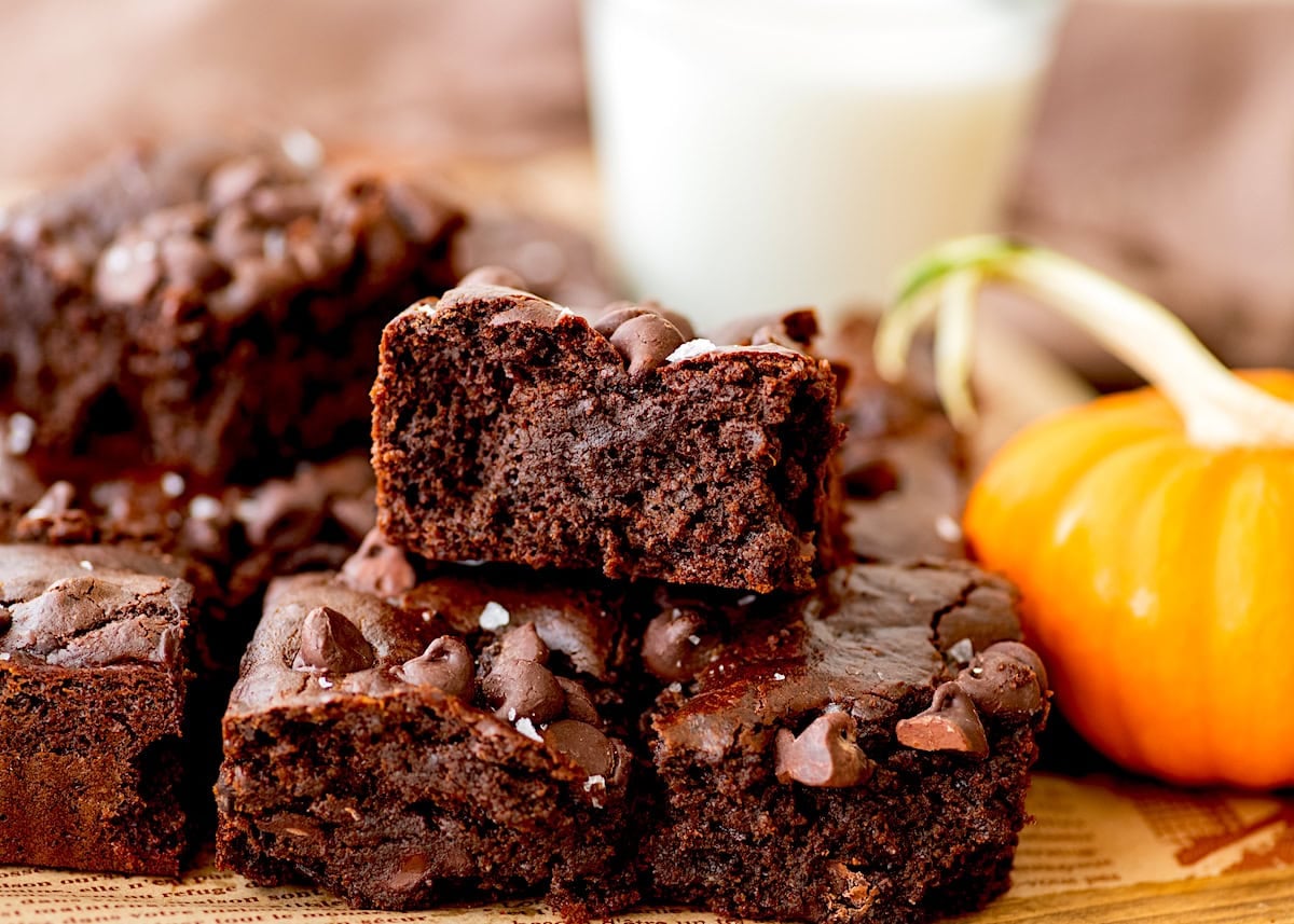 flourless pumpkin brownies cut into squares and stacked on top of each other. 