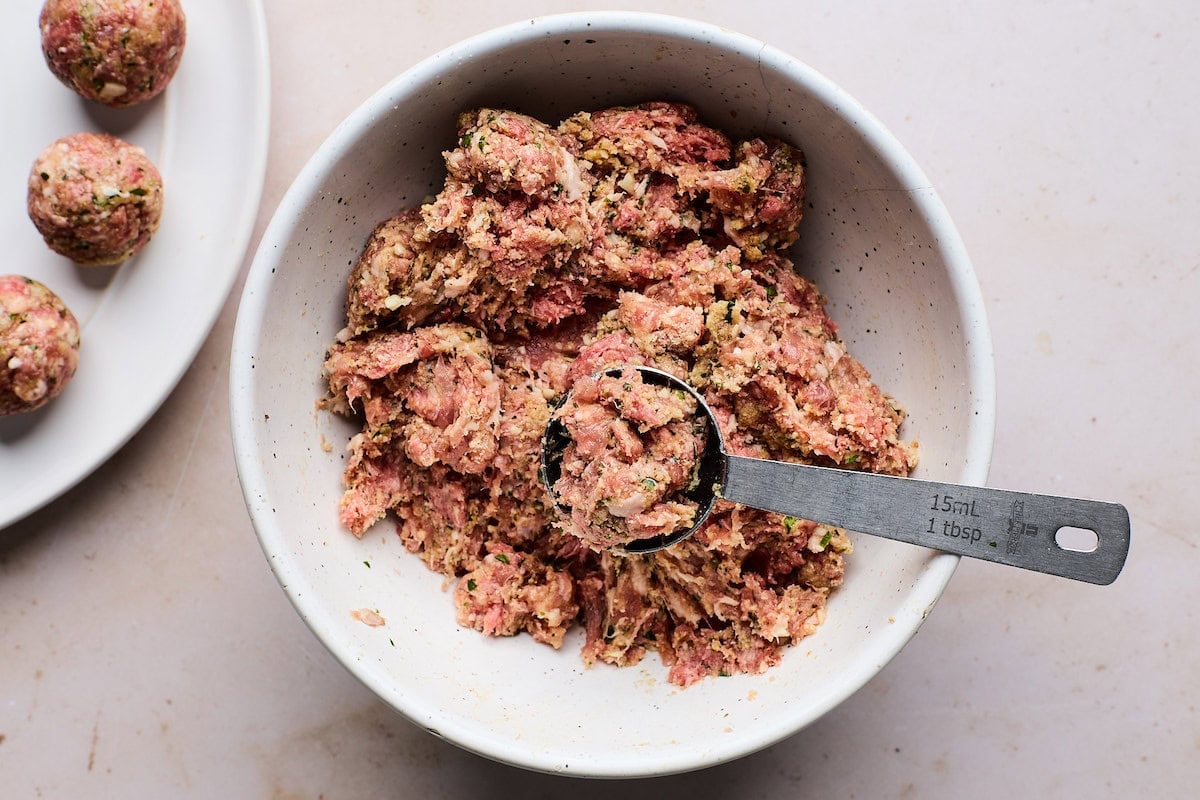 meatball mixture being formed into small meatballs.