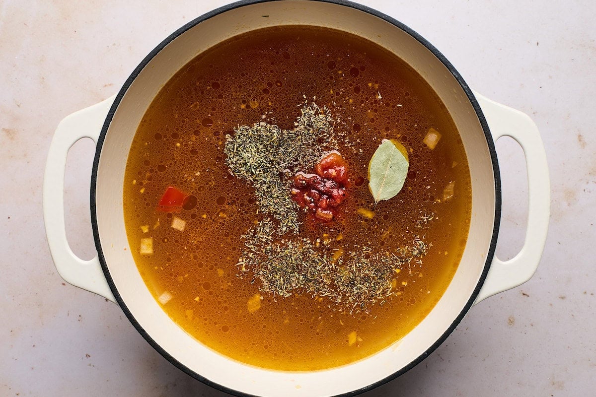spices being added to meatball orzo soup.