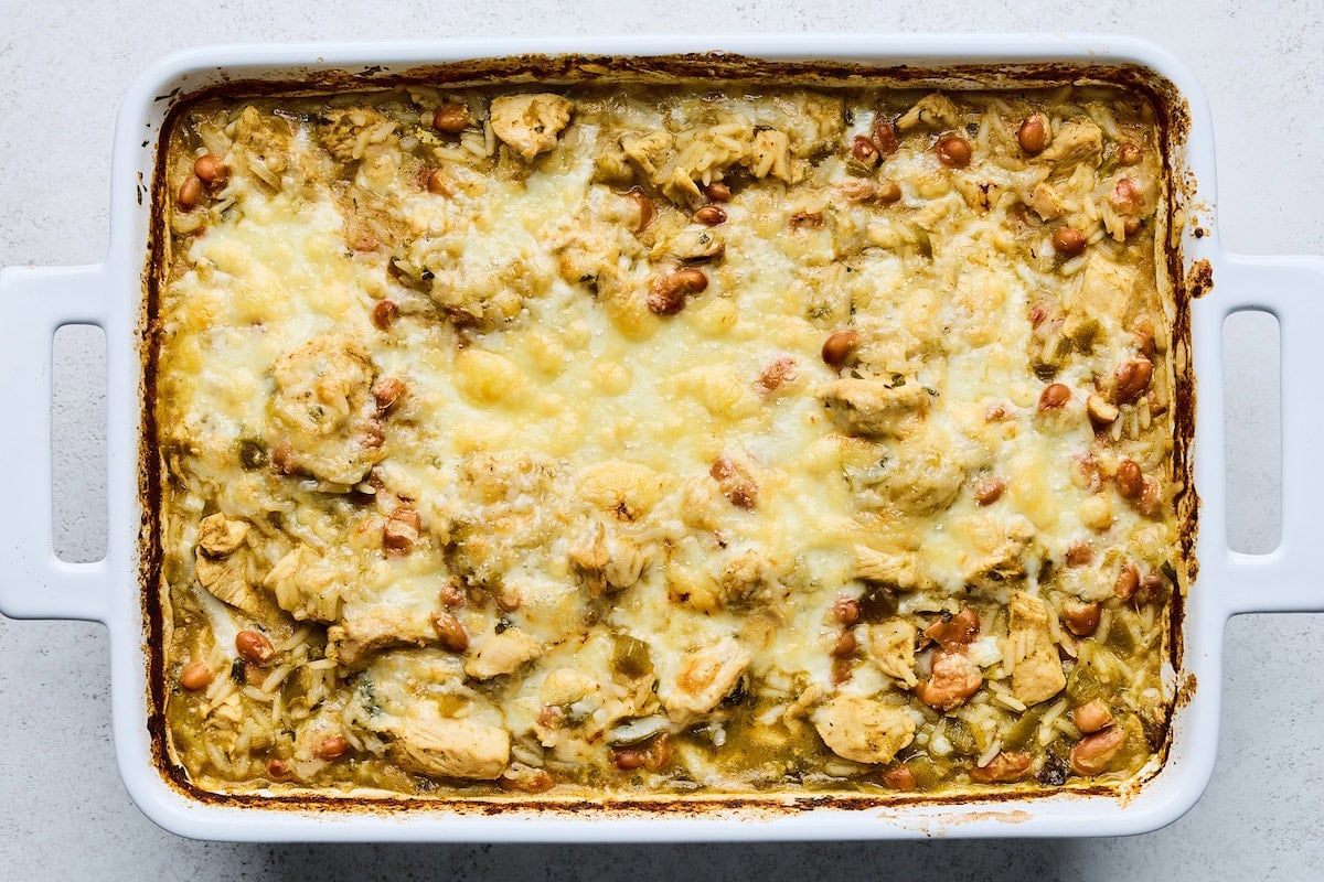 salsa verde chicken and rice with melty cheese in baking dish.