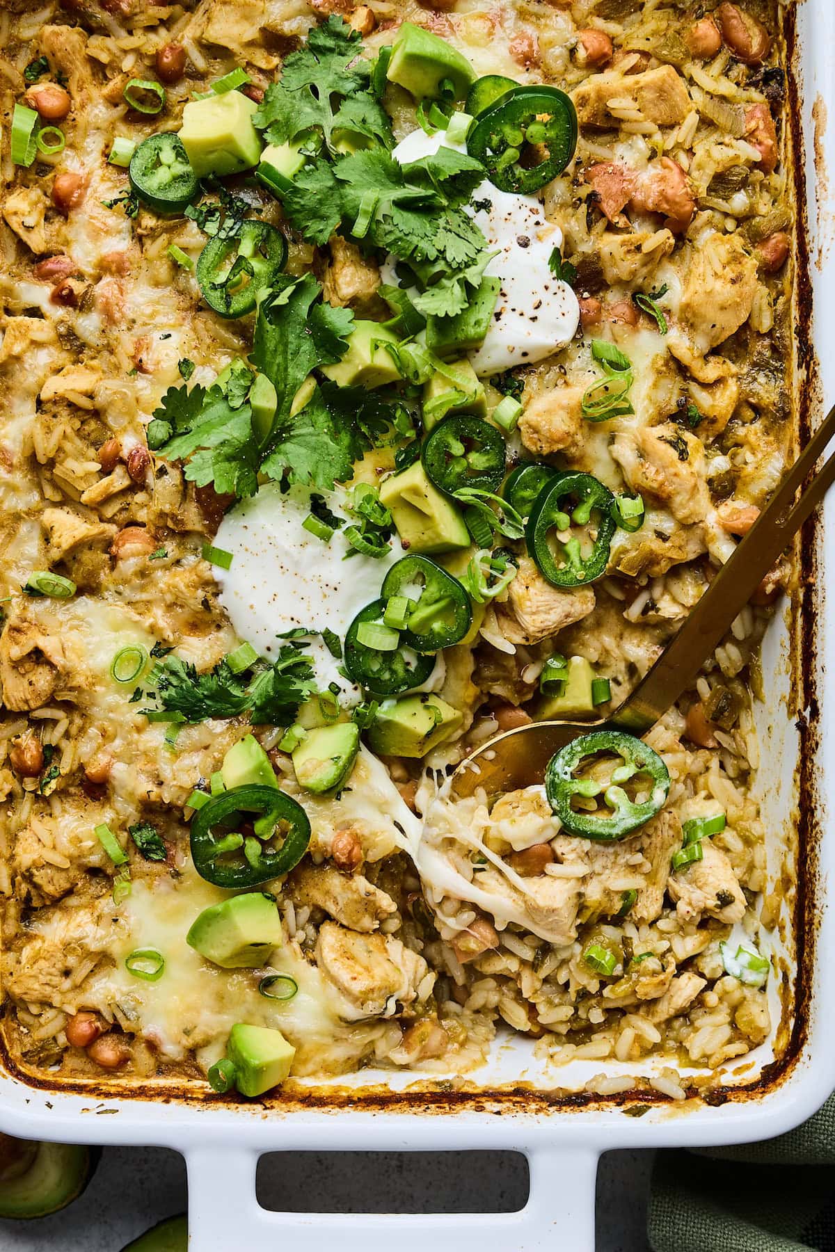 close up of salsa verde chicken and rice in pan with serving spoon.
