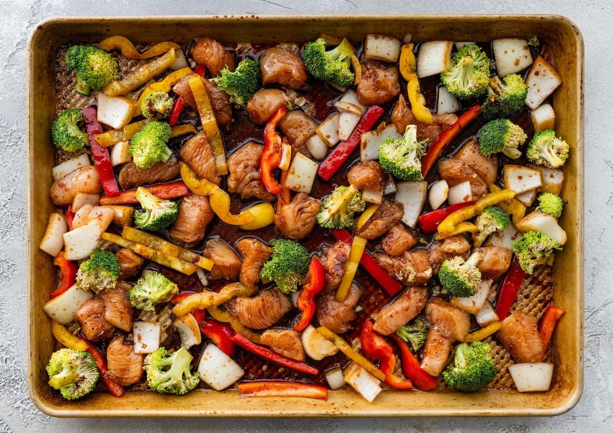 chicken, broccoli, peppers, and onion on sheet pan with honey garlic sauce.