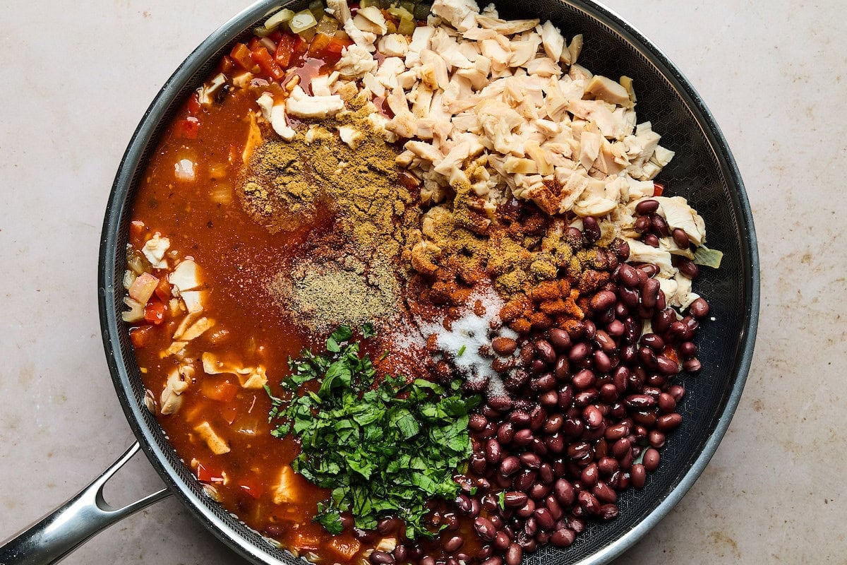 sweet potato chicken enchilada bake filling in skillet.