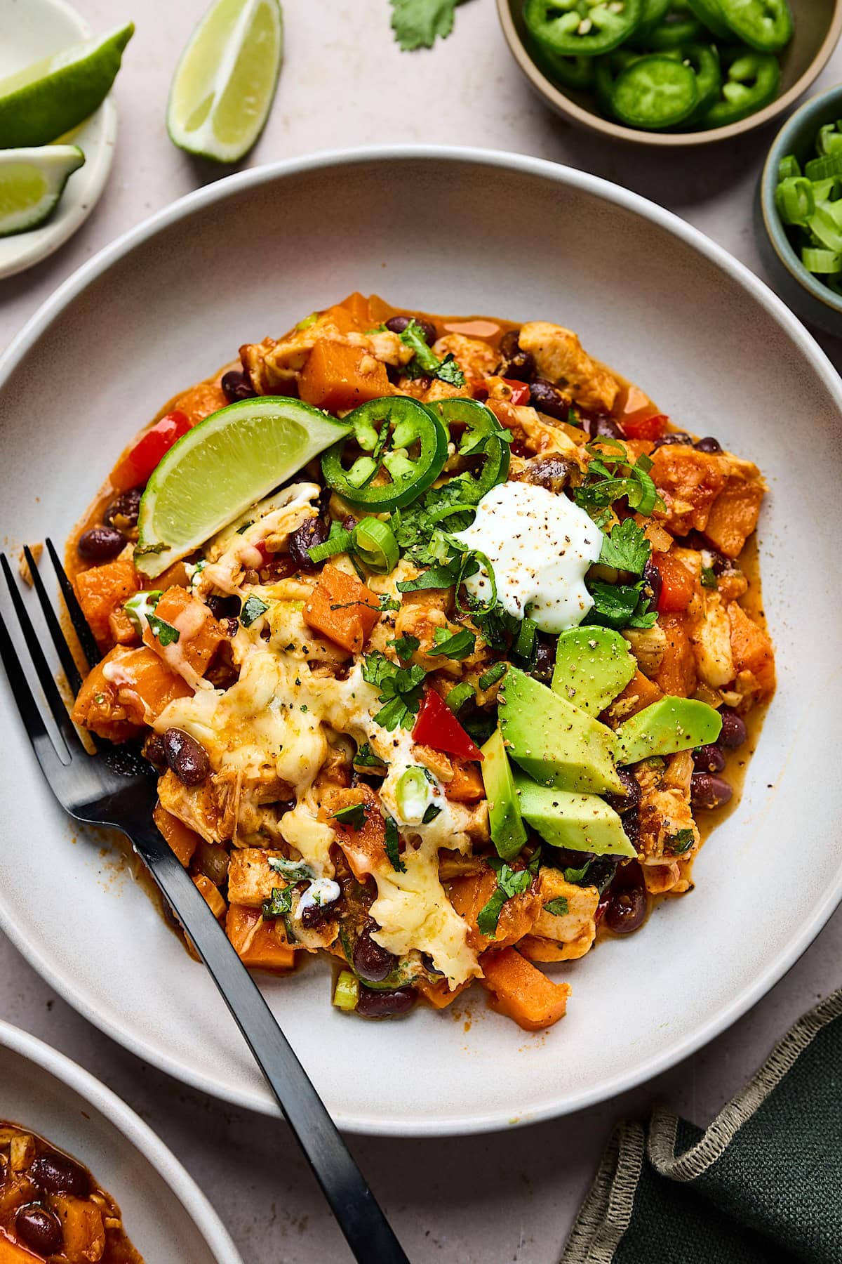 sweet potato chicken enchilada bake on plate with fork.