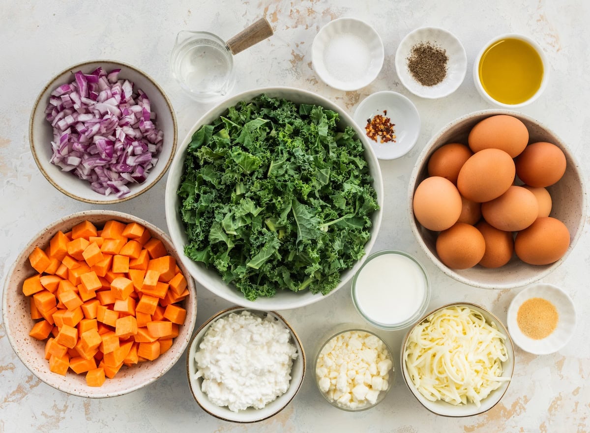 ingredients in bowls to make sweet potato kale breakfast casserole.