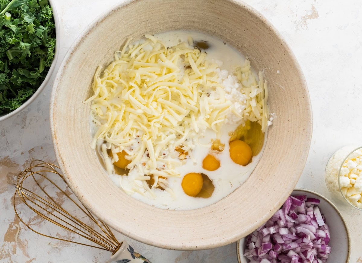 eggs, cheese, and milk mixture in bowl to make sweet potato kale breakfast casserole.